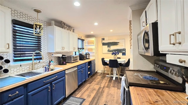 kitchen with white cabinets, a sink, appliances with stainless steel finishes, blue cabinetry, and backsplash