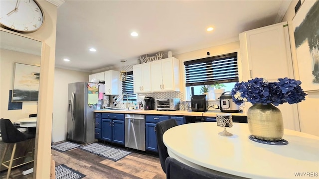 kitchen with recessed lighting, wood finished floors, blue cabinetry, stainless steel appliances, and a sink