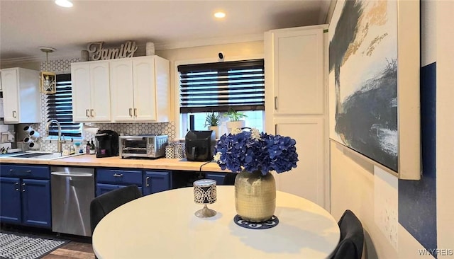 kitchen featuring blue cabinetry, backsplash, white cabinets, and a sink