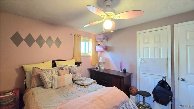 bedroom featuring a wall unit AC and a ceiling fan