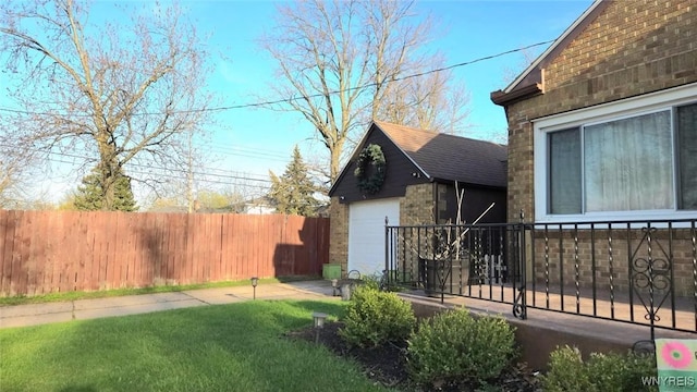 view of property exterior with a garage, a lawn, brick siding, roof with shingles, and fence