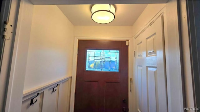 entryway with wainscoting and a decorative wall