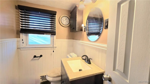 bathroom with wainscoting, toilet, and vanity