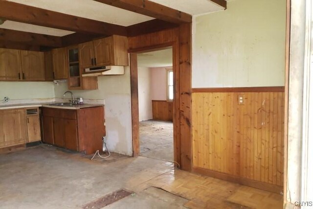 24 Railroad St, Elbridge, NY 13080 - kitchen featuring a sink, light countertops, under cabinet range hood, wooden walls, and wainscoting
