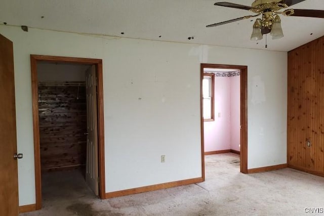 24 Railroad St, Elbridge, NY 13080 - unfurnished bedroom featuring baseboards, a closet, wood walls, light carpet, and a walk in closet