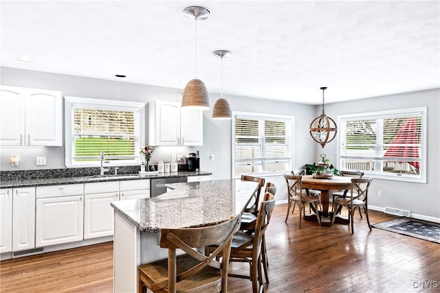 kitchen with stainless steel dishwasher, plenty of natural light, a sink, and visible vents