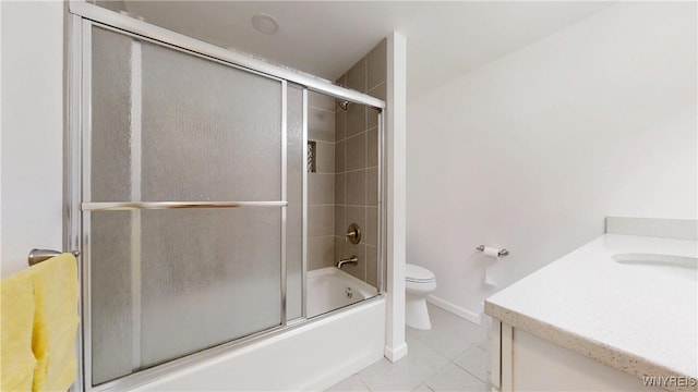 full bathroom with tile patterned floors, combined bath / shower with glass door, toilet, vanity, and baseboards