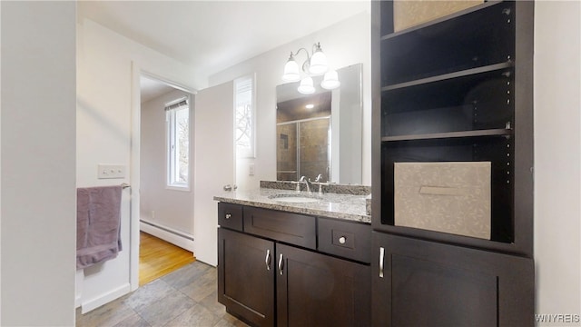 bathroom featuring a stall shower, vanity, and baseboard heating