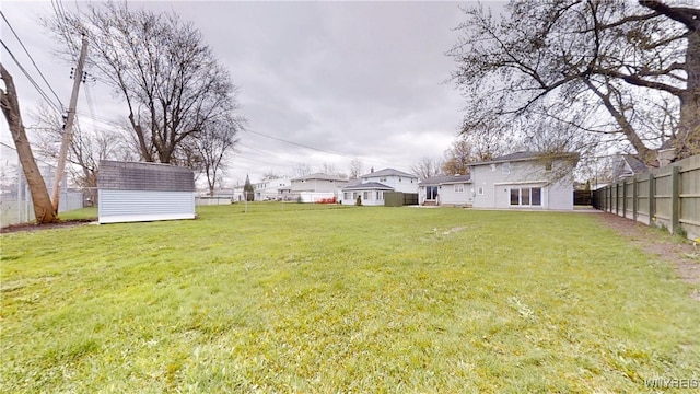 view of yard with fence, a storage shed, and an outdoor structure