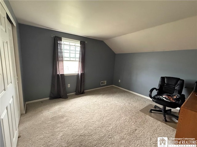 unfurnished office featuring baseboards, visible vents, carpet, and vaulted ceiling