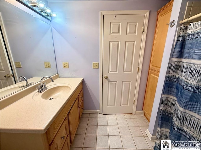 full bath with tile patterned floors, vanity, and baseboards