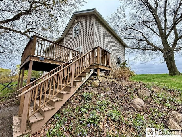 rear view of property featuring a deck and stairs