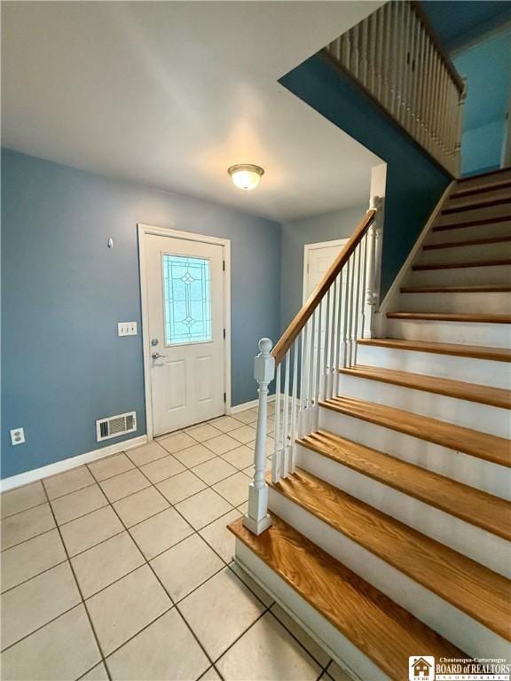 foyer with visible vents, stairway, tile patterned floors, and baseboards