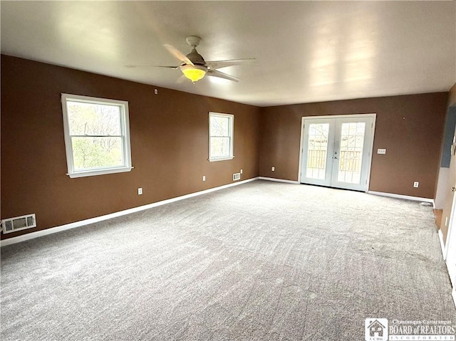 empty room with visible vents, a ceiling fan, french doors, and plenty of natural light