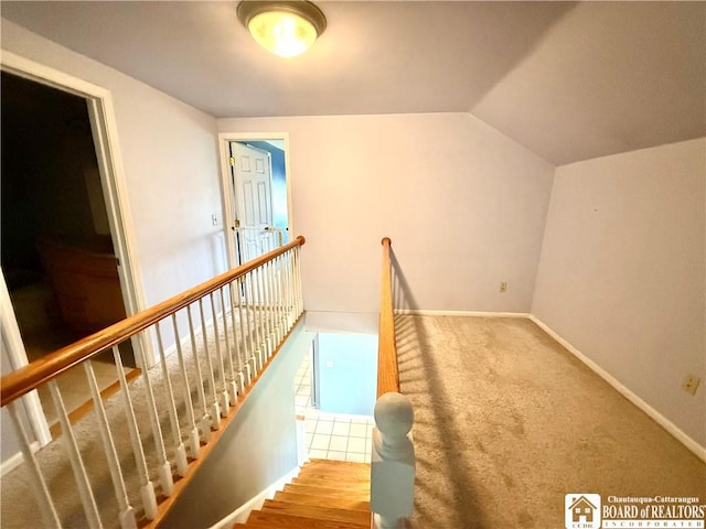 stairs with baseboards, lofted ceiling, and carpet floors