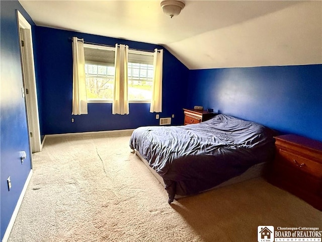bedroom featuring lofted ceiling, baseboards, and carpet floors
