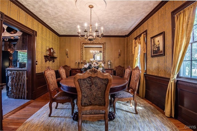 dining room with a chandelier, light wood-type flooring, and ornamental molding