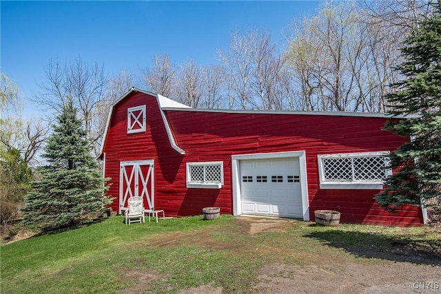 view of barn featuring driveway and a lawn