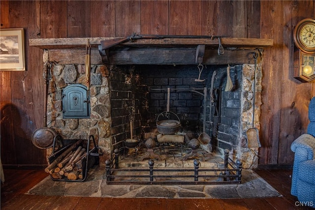 interior details featuring wood walls, wood finished floors, and a wood stove