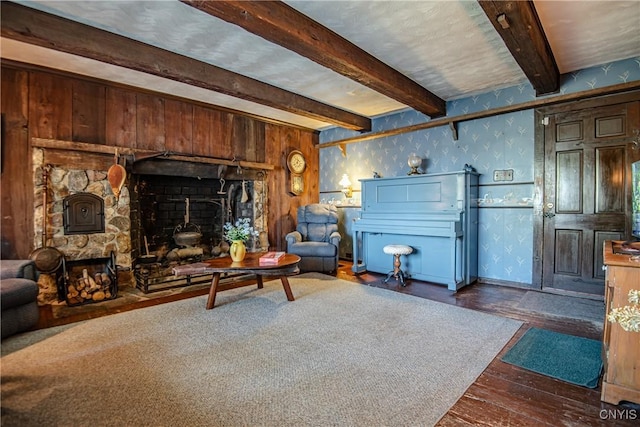 living room with wallpapered walls, beam ceiling, hardwood / wood-style flooring, and a fireplace