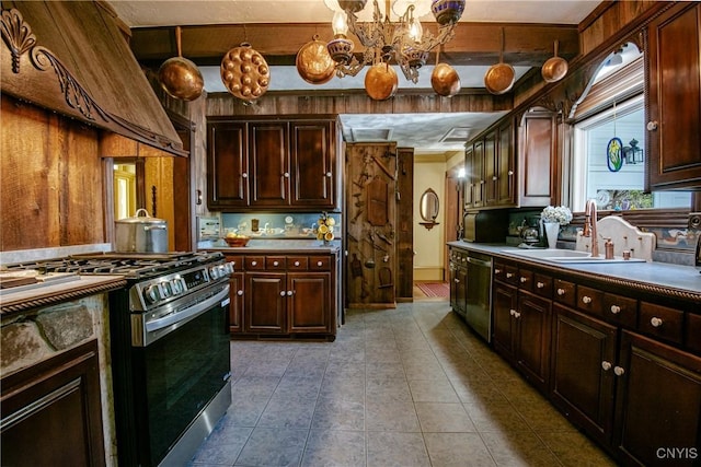 kitchen featuring an inviting chandelier, tile patterned flooring, stainless steel appliances, range hood, and a sink