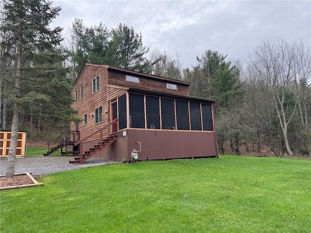 view of property exterior with a yard, a sunroom, and stairway