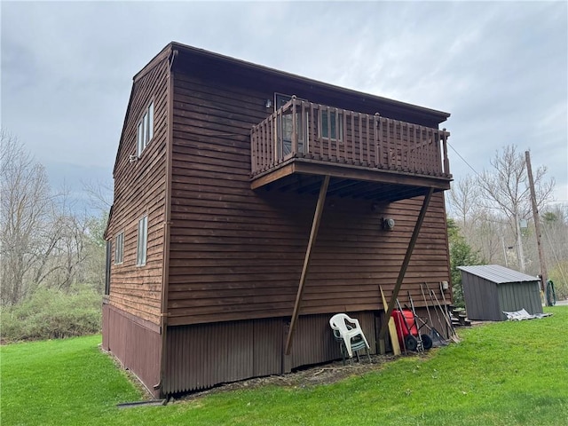 view of side of property with a storage shed, an outbuilding, a yard, and a balcony