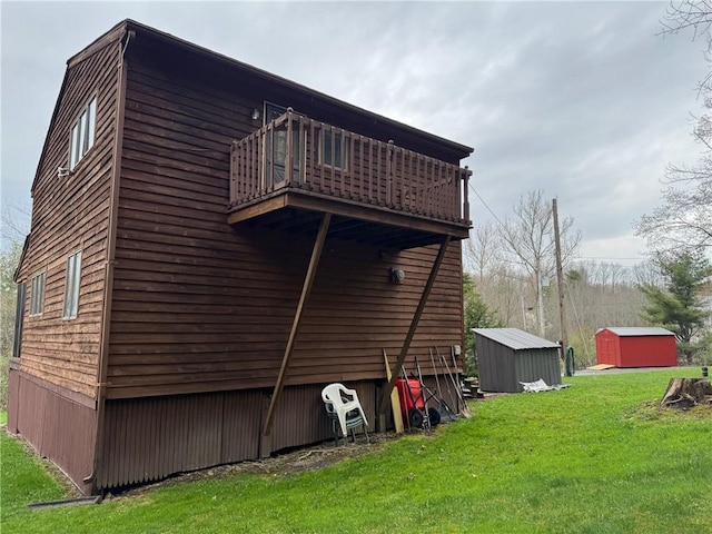 view of home's exterior featuring a lawn, an outbuilding, a shed, and a balcony