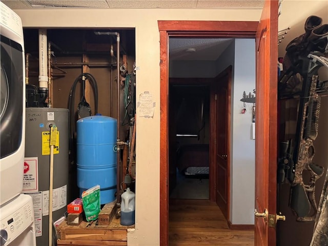 utilities featuring stacked washer and clothes dryer and gas water heater