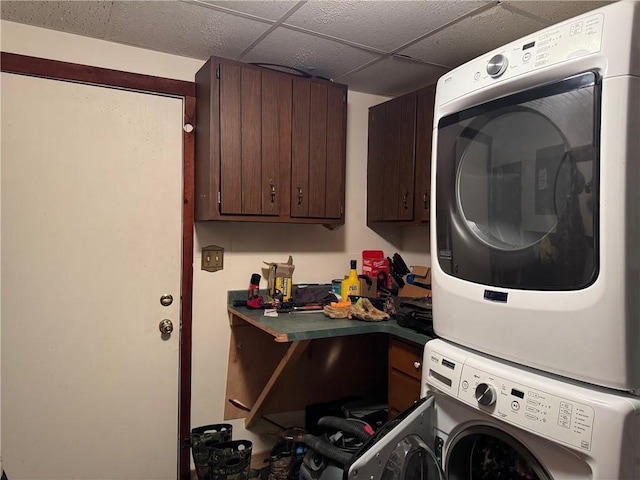 laundry area with stacked washer / drying machine and cabinet space