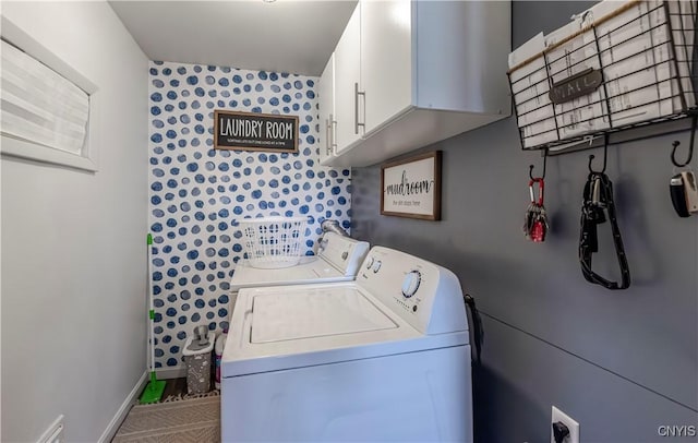 laundry area featuring washer and clothes dryer, cabinet space, and baseboards