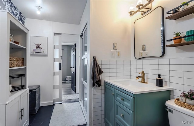 bathroom with tile walls, toilet, and vanity