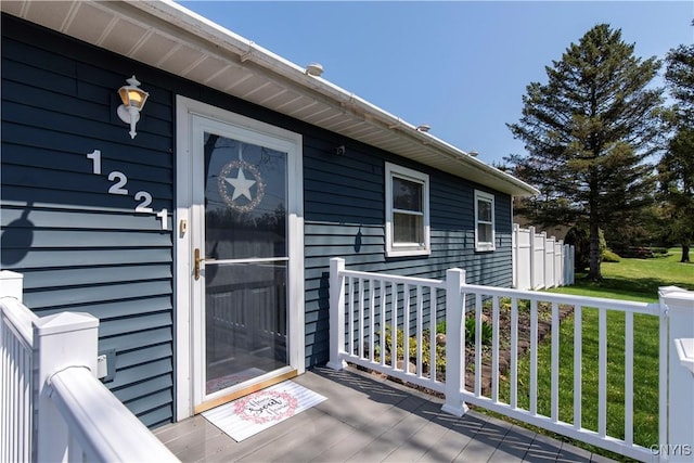 entrance to property with a yard and a wooden deck