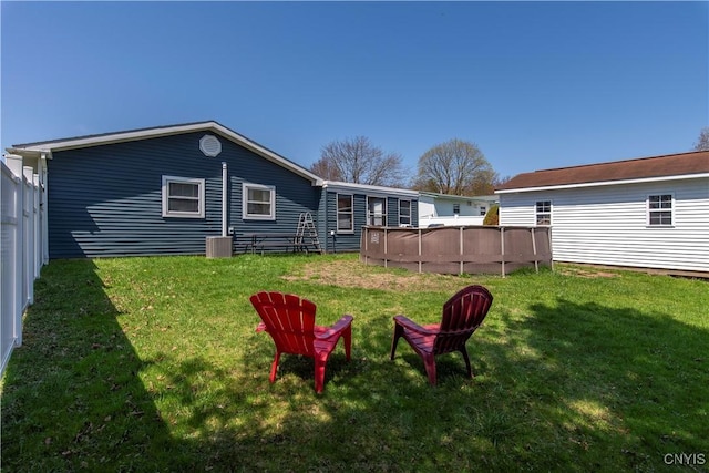 view of yard with central AC and an outdoor pool