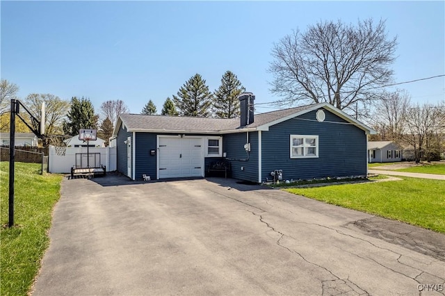 ranch-style house featuring fence, driveway, a front yard, and a garage