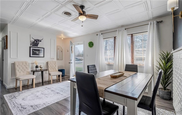 dining room featuring ceiling fan, wood finished floors, an ornate ceiling, and visible vents