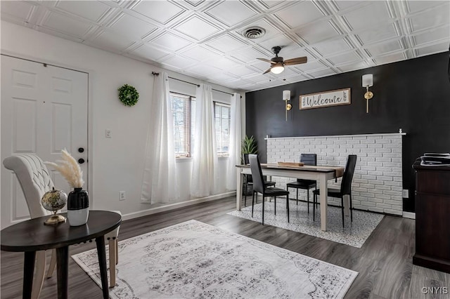 dining room featuring dark wood-style flooring, ceiling fan, an ornate ceiling, visible vents, and baseboards