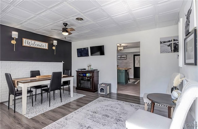 dining area with wood finished floors, an ornate ceiling, baseboards, visible vents, and a ceiling fan