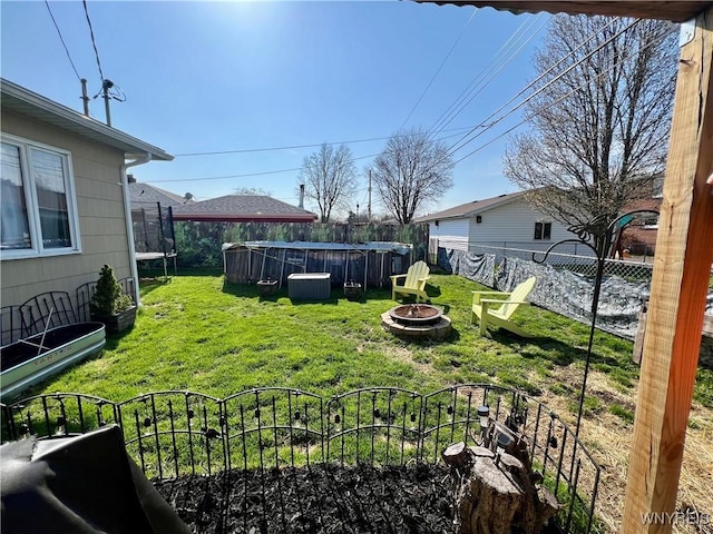view of yard featuring central AC, a fire pit, and a fenced backyard