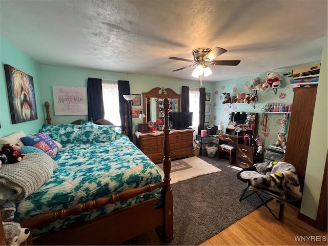 bedroom featuring a textured ceiling, ceiling fan, and wood finished floors