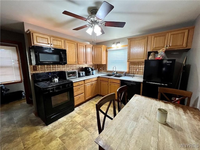 kitchen featuring black appliances, light countertops, backsplash, and a sink