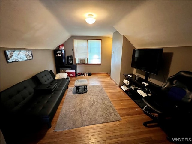 living area with lofted ceiling, hardwood / wood-style floors, and cooling unit