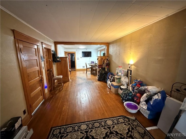 corridor featuring wood finished floors and ornamental molding