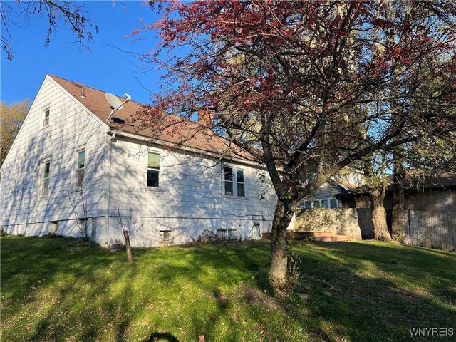 view of side of home with a lawn and a chimney