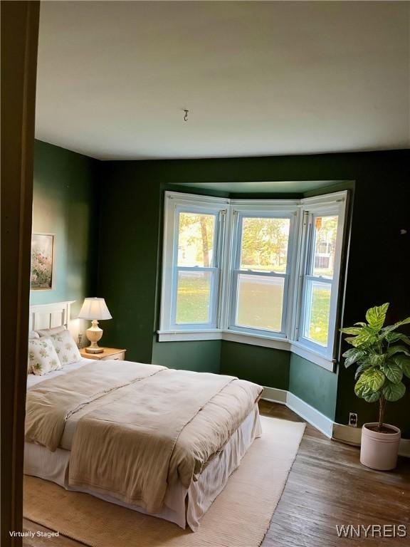 bedroom with wood finished floors and baseboards