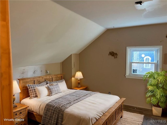 bedroom with lofted ceiling, wood finished floors, and baseboards