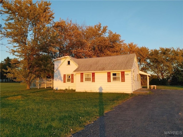 view of front facade with a front yard and aphalt driveway