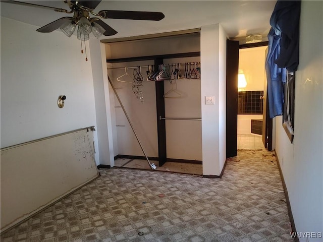 unfurnished bedroom featuring a ceiling fan, carpet flooring, and a closet