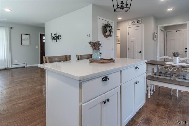 kitchen with recessed lighting, a center island, white cabinetry, light countertops, and dark wood finished floors