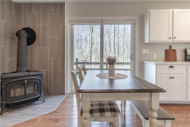 dining space featuring light wood finished floors and a wood stove